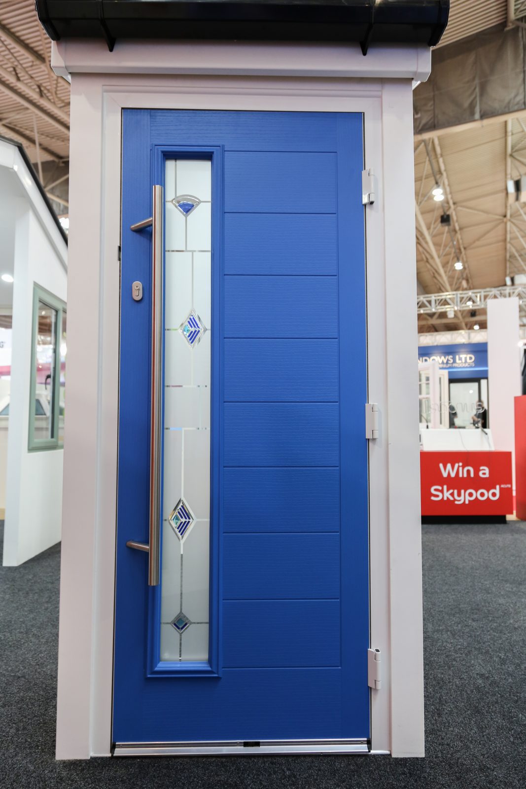 blue composite front door with pull bar in display frame