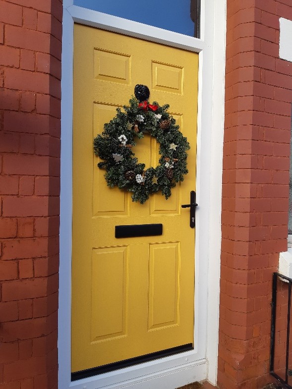 Block yellow front door with xmas wreath