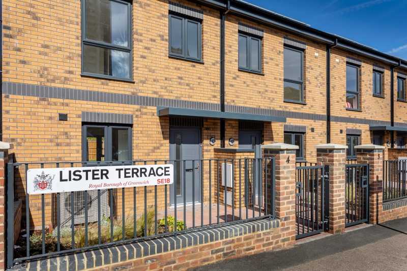 Newly built terraced housing at Lister Terrace in the Royal Borough of Greenwich, featuring a sleek gray XtremeDoor composite door. The door's contemporary design contrasts well with the warm brickwork, complementing the modern aesthetic of the development.