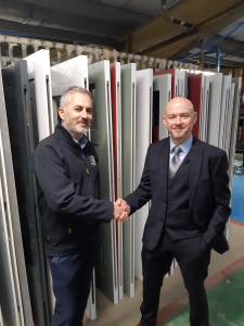 shot of 2 men shaking hands to agree business deal in front of doors